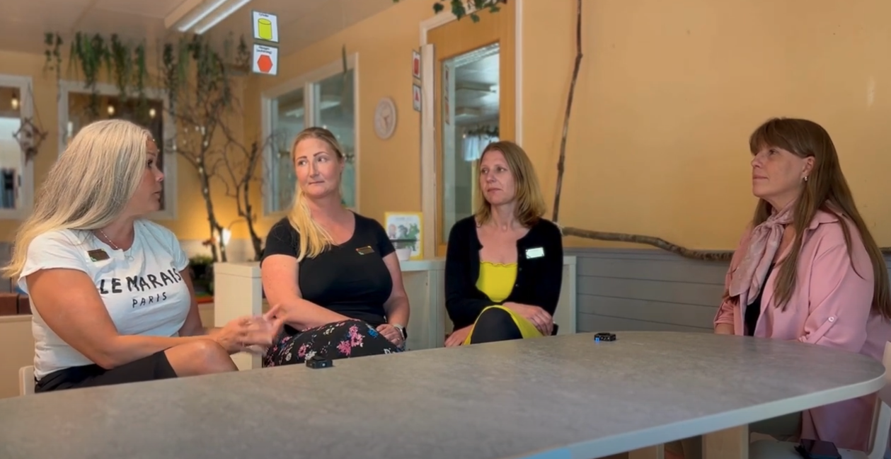 Sara sitter runt ett bord tillsammans med rektor Maria och hennes anställda.