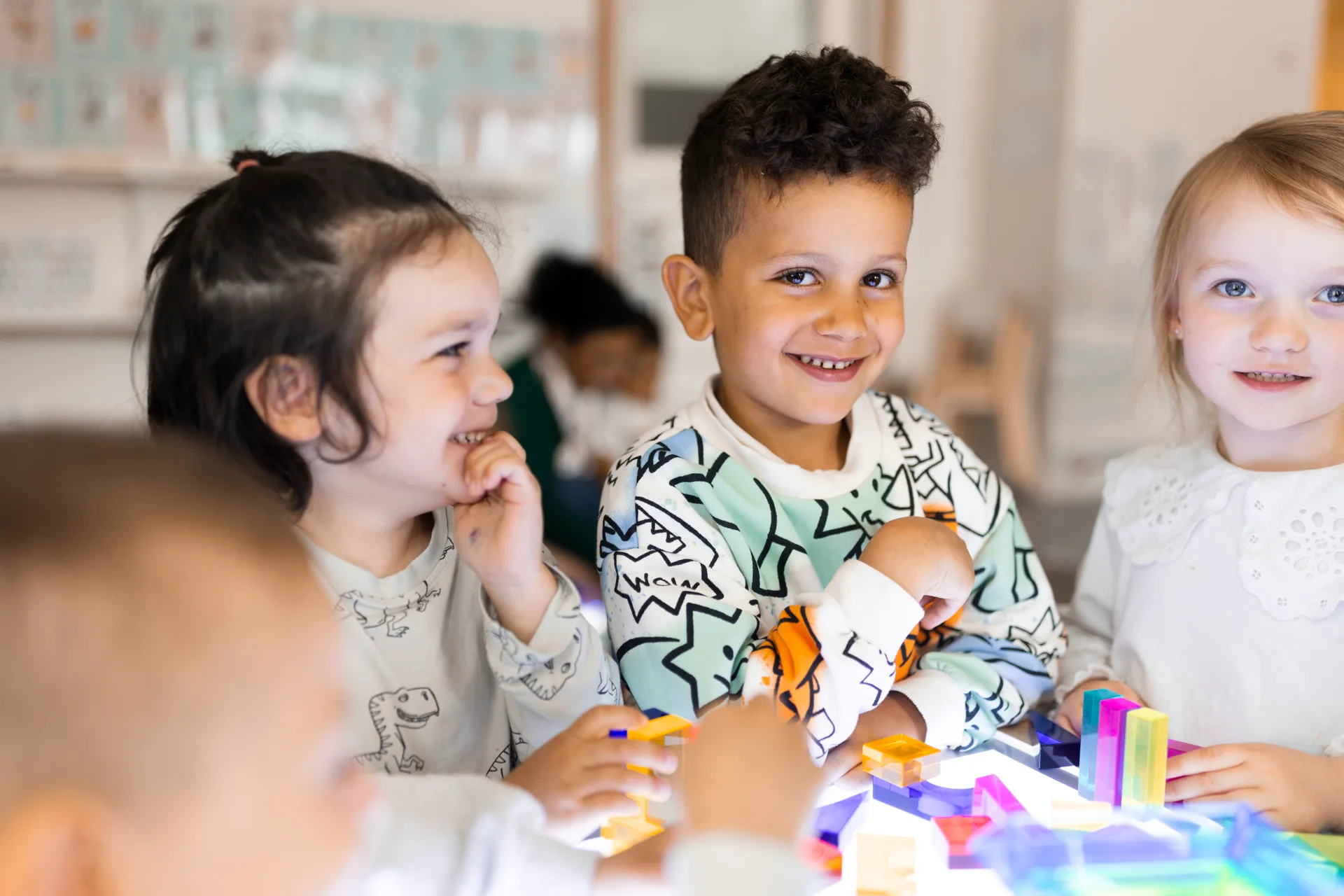 En grupp små barn som sitter vid ett bord.