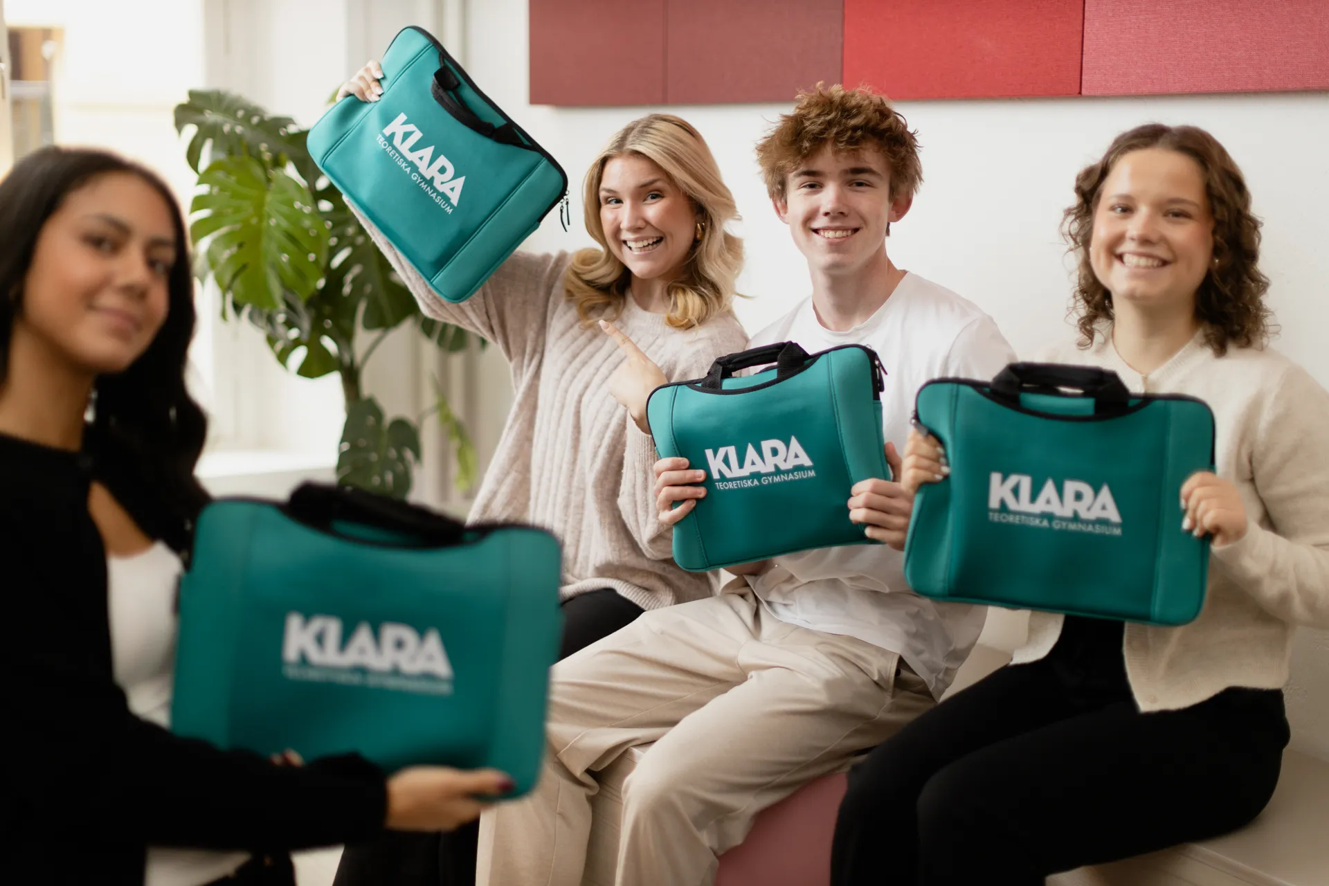 En grupp människor som sitter på en soffa och håller i väskor.