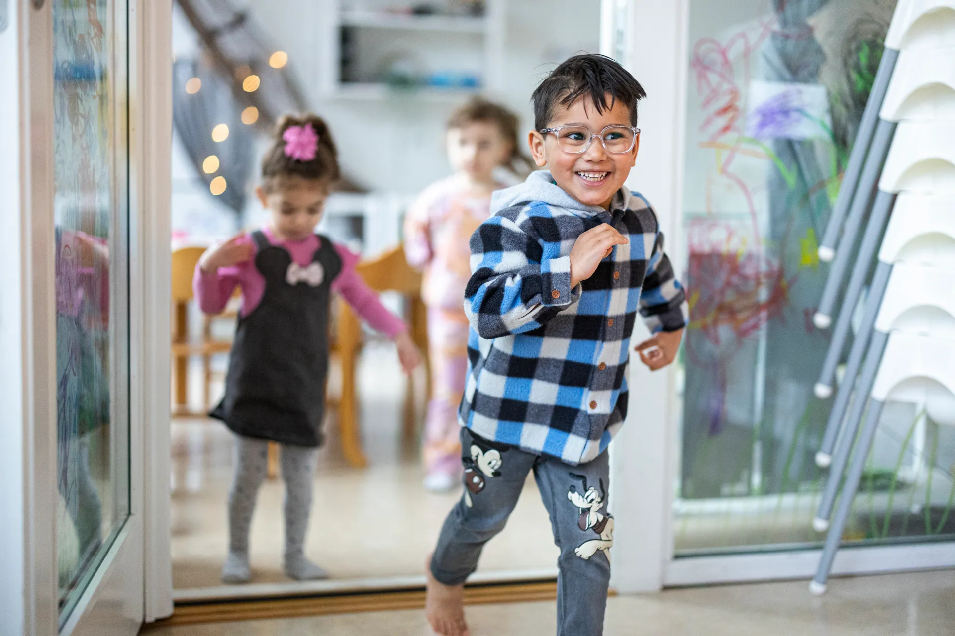 En ung pojke med glasögon och rutig skjorta.